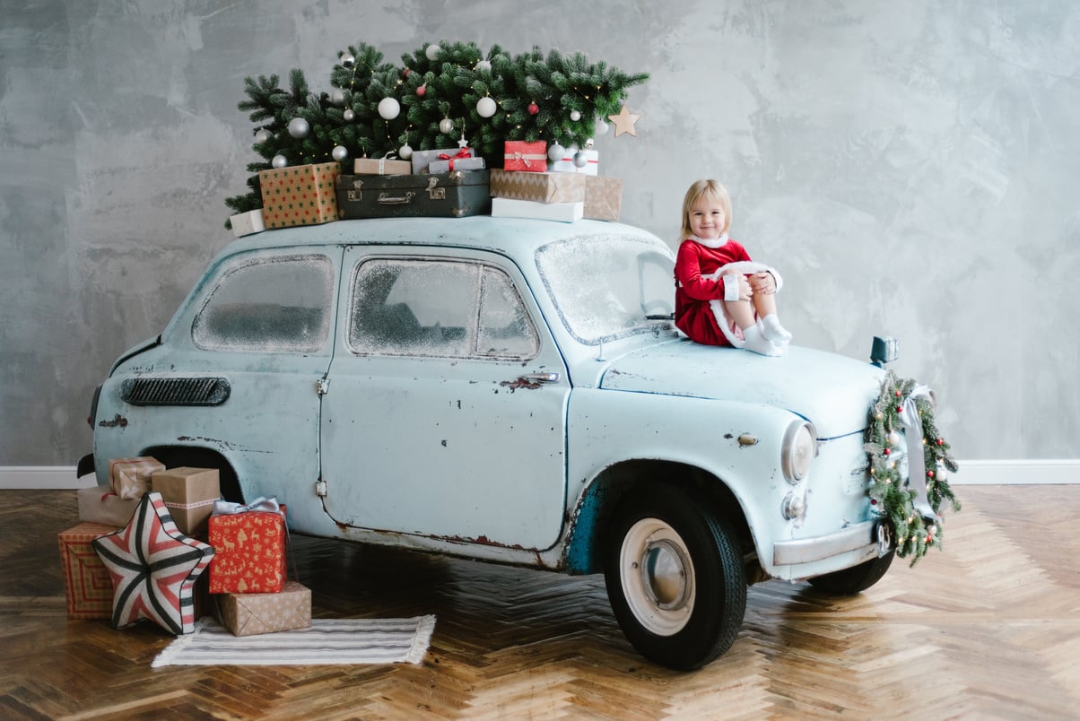 Girl sitting on the old car in the room